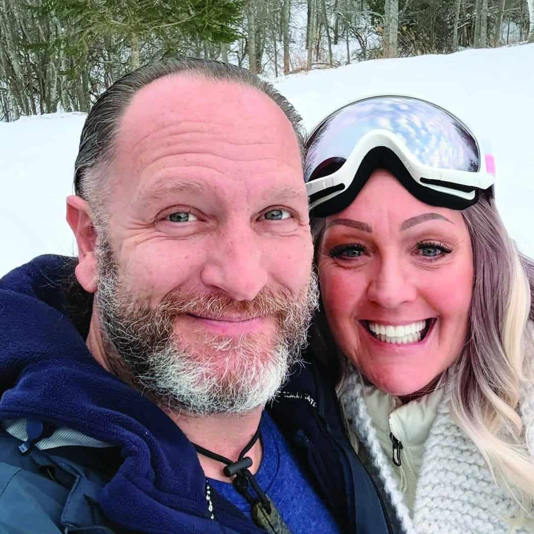 Brandi Taylor and her husband smiling together outdoors in winter gear